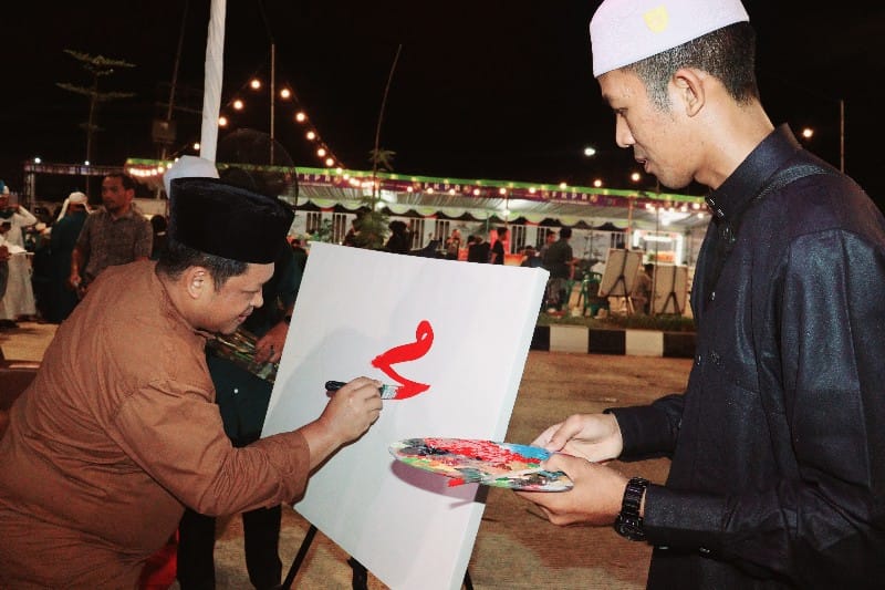 Kepala Dispora Kukar, Aji Ali Husni turut menggambar kaligrafi bersama peserta lomba (Adv/Ruteberita)
